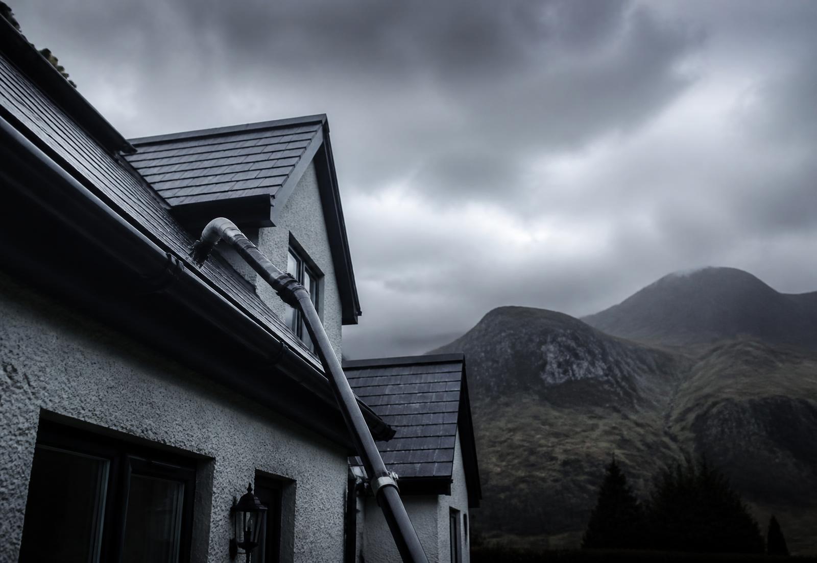 Gutter vacuum pole cleaning a house roofline in North Wales